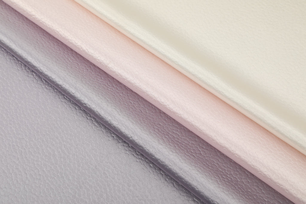 Polka dot embossed satin fabric, 185 g/m² woven polyester, suitable for elegant women's clothing.