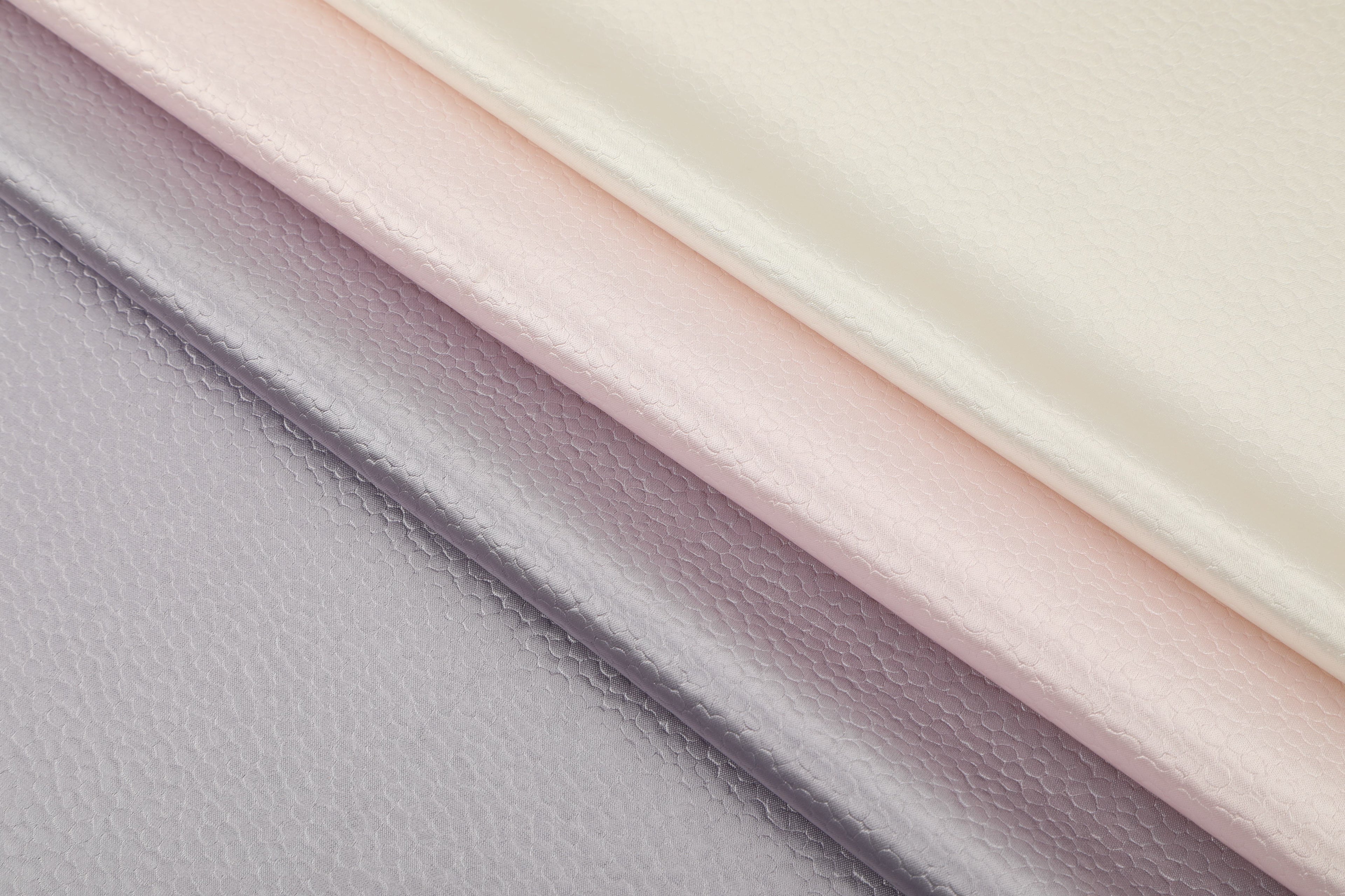 Polka dot embossed satin fabric, 185 g/m² woven polyester, suitable for elegant women's clothing.