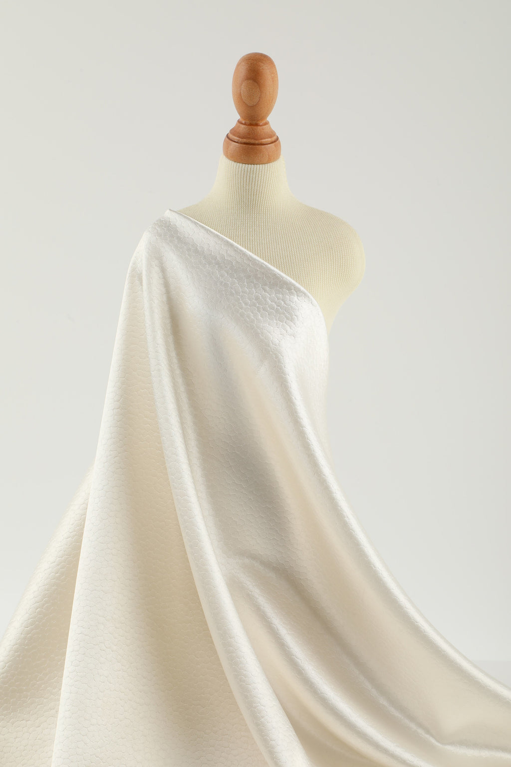 Polka dot embossed satin fabric, 185 g/m² woven polyester, suitable for elegant women's clothing.