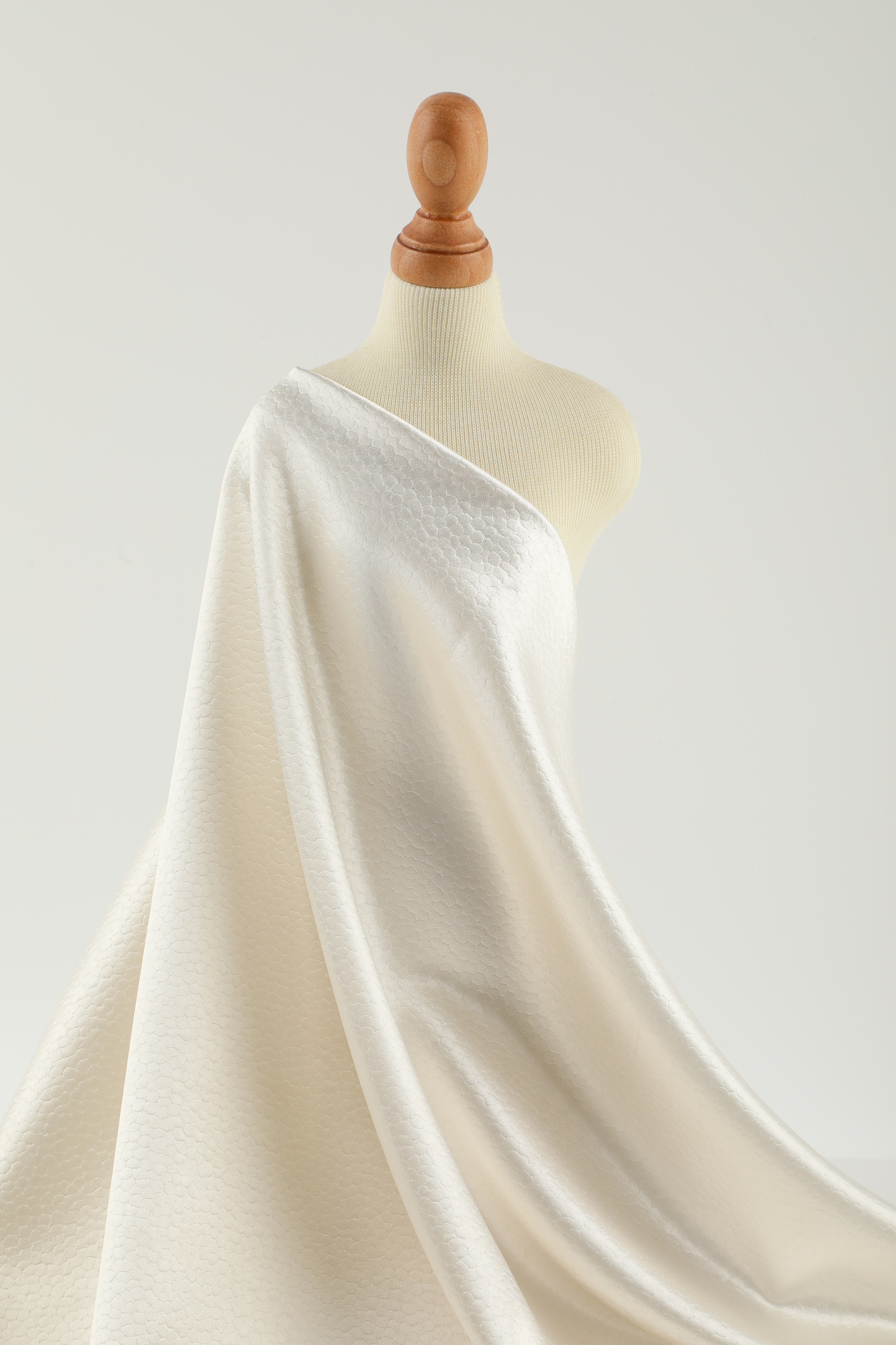 Polka dot embossed satin fabric, 185 g/m² woven polyester, suitable for elegant women's clothing.