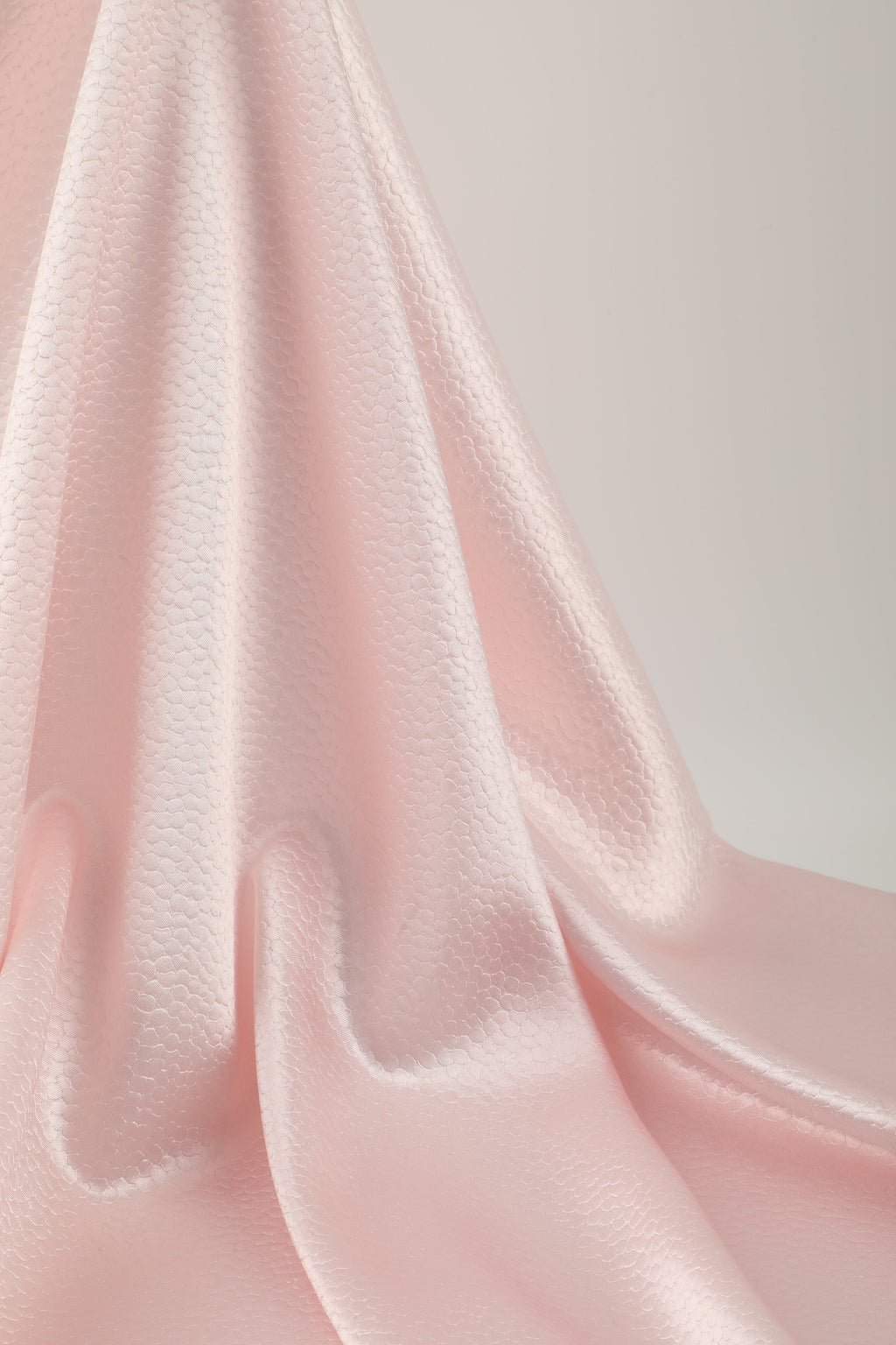 Polka dot embossed satin fabric, 185 g/m² woven polyester, suitable for elegant women's clothing.