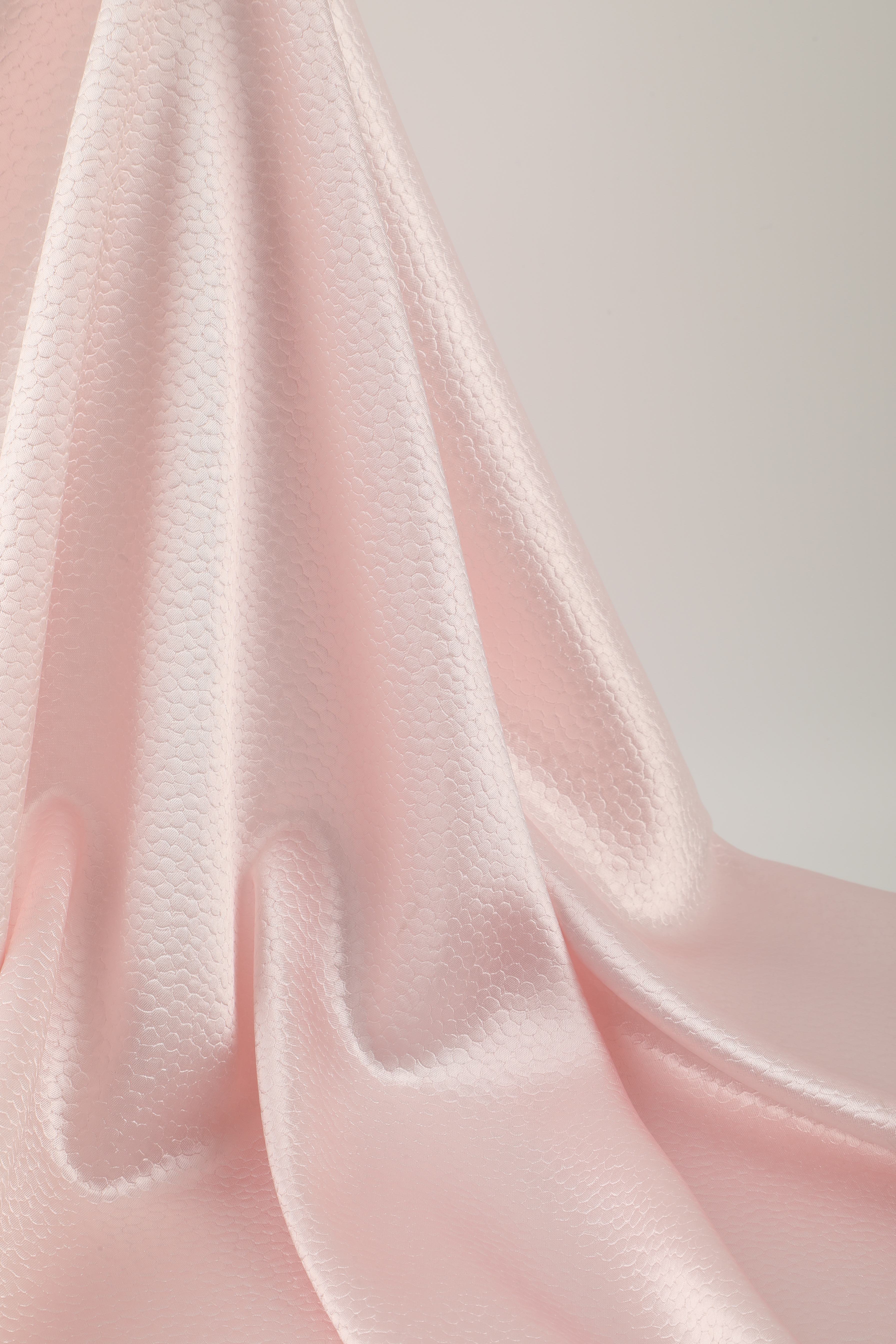 Polka dot embossed satin fabric, 185 g/m² woven polyester, suitable for elegant women's clothing.